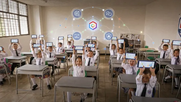 Primary school students hold up their tablets, with a grid of connections overlaid on the scene